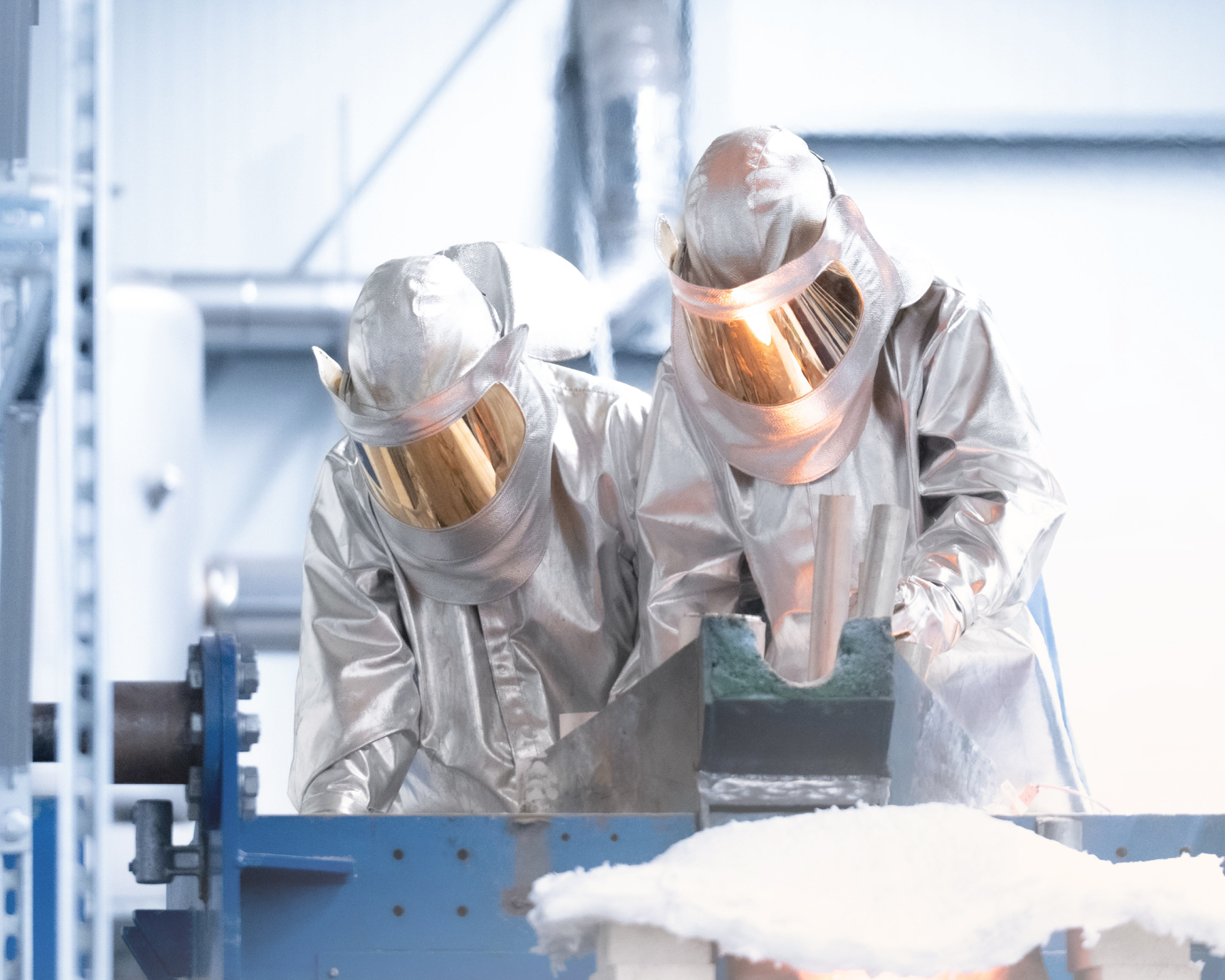 Steel CleanUp operators in heat suits casting recovered metal